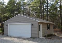 24x28 Gable Garage with 5/12 roof pitch, window, 9 lite door and vinyl siding in Virginia built by Sheds by Ken